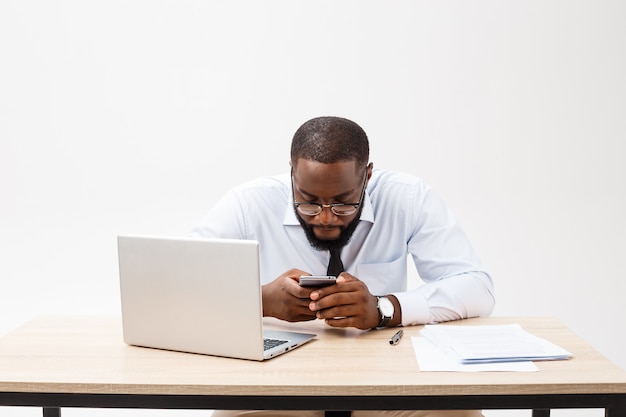 El negocio es su vida. Hombre africano joven alegre en ropa formal y trabajando en la computadora portátil