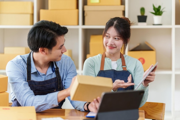 Negocio feliz Puesta en marcha de una pequeña empresa con caja de paquetes para entregar al cliente y trabajar juntos en casa