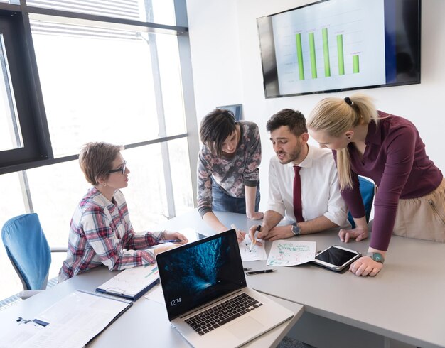 negocio de inicio, grupo de jóvenes creativos con lluvia de ideas sobre reuniones en el interior de la oficina y uso de computadoras portátiles y tabletas para anotar ideas, planes y proyectos