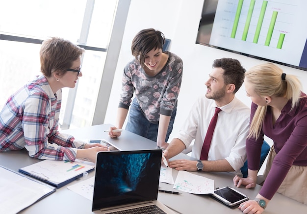 negocio de inicio, grupo de jóvenes creativos con lluvia de ideas sobre reuniones en el interior de la oficina y uso de computadoras portátiles y tabletas para anotar ideas, planes y proyectos