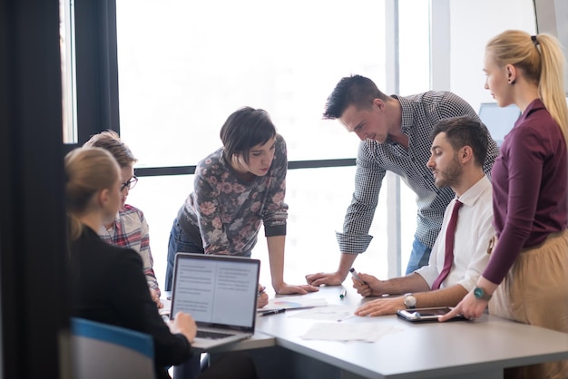 negocio de inicio, grupo de jóvenes creativos con lluvia de ideas sobre reuniones en el interior de la oficina y uso de computadoras portátiles y tabletas para anotar ideas, planes y proyectos