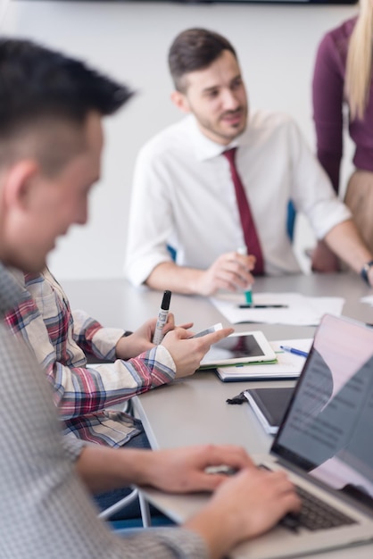 negocio de inicio, grupo de jóvenes creativos con lluvia de ideas sobre reuniones en el interior de la oficina y uso de computadoras portátiles y tabletas para anotar ideas, planes y proyectos