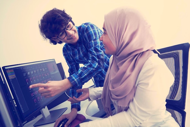 negocio de inicio, jóvenes profesionales creativos equipo de personas discutiendo sobre reunirse en una oficina brillante mientras señalan en una computadora de pantalla de monitor dual para sugerencias y ayuda en el proyecto