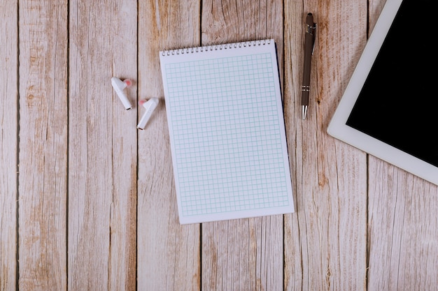 Negocio de mesa de oficina con notebook en dispositivo con pantalla táctil, auriculares inalámbricos con pluma