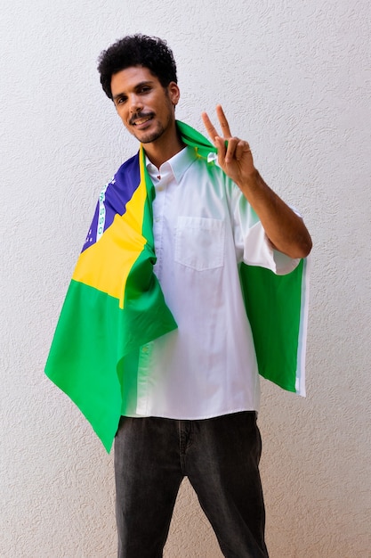 Negocio o trabajador sosteniendo una bandera de Brasil aislada en blanco. Imagen de concepto de bandera y día de la independencia.