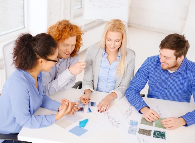 negocio, oficina, diseño de ropa y concepto de puesta en marcha - equipo creativo sonriente mirando boceto