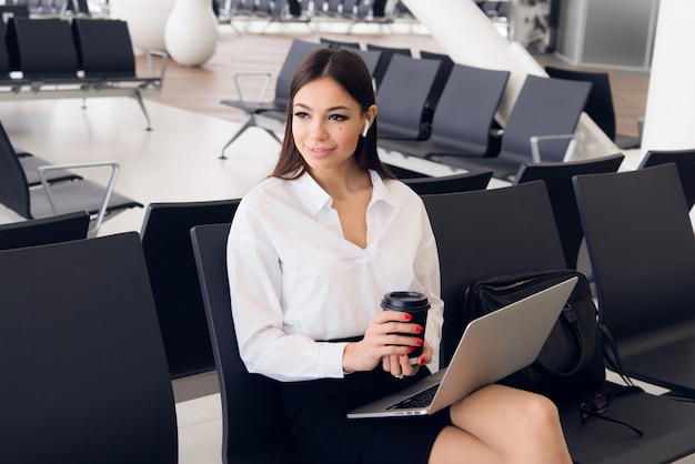 Negocio de recreo. Hermosa mujer de negocios trabajando en la computadora portátil mientras espera su vuelo en un aeropuerto