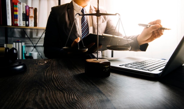 Foto negocios y abogados discutiendo documentos contractuales con escala de latón en el escritorio en la oficina asesoramiento de servicios legales de derecho imagen conceptual de justicia y derecho con efecto de grano de película