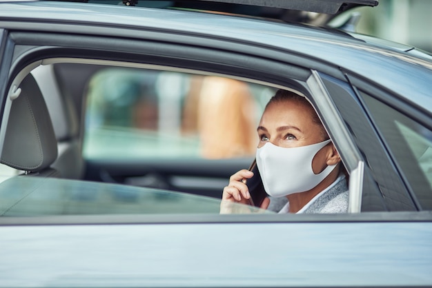 Negócios como novo conceito normal, vista lateral de uma empresária caucasiana usando protetor médico