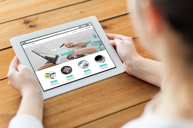 negócios, compras na internet, pessoas e conceito de tecnologia - close-up da mulher com página da web de loja online na tela do computador tablet pc