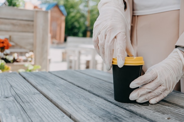 Negócios de alimentos e bebidas durante a pandemia de coronavírus café para levar para viagem em mãos femininas