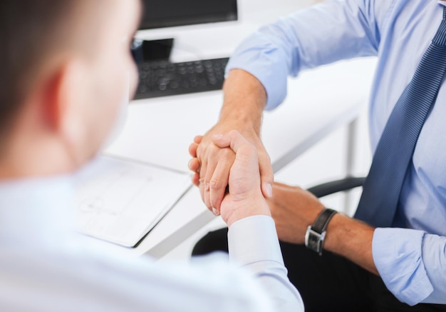 Negócios e conceito de escritório - dois empresários apertando as mãos no escritório