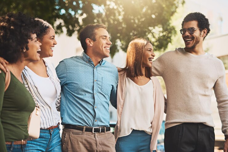 Foto negócios e sorrisos com um grupo de amigos ao ar livre juntos para fazer uma pausa de ligação ou apoio comédia engraçada ou rir com feliz e e mulher empregado abraço depois do trabalho para colaboração diversão ou trabalho em equipe