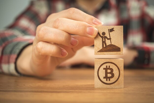 Negocios exitosos con bitcoin Concepto de inversión y éxito Cubos de madera con BTC y empresario icono foto de primer plano