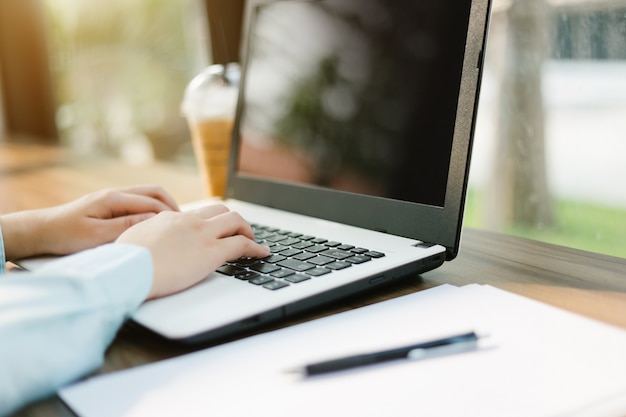 negócios feminino trabalhando com laptop com tela preta em branco, fazer um documento nota e inteligente