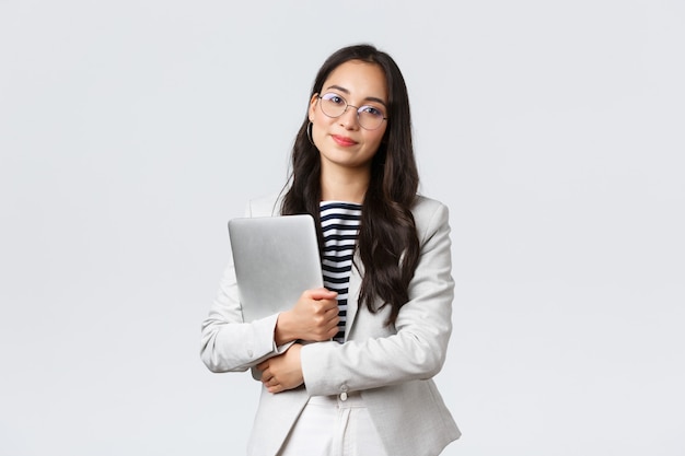 Foto negócios, finanças e emprego, conceito de empresários bem sucedidos feminino. jovem empresária asiática, funcionário do banco de óculos, segurando laptop