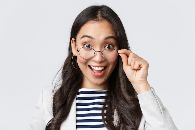 Negocios, finanzas y empleo, concepto de mujeres emprendedoras exitosas. Trabajador de oficina asiático feliz emocionado que se quita las gafas y sonriendo asombrado al recibir un trato increíble.