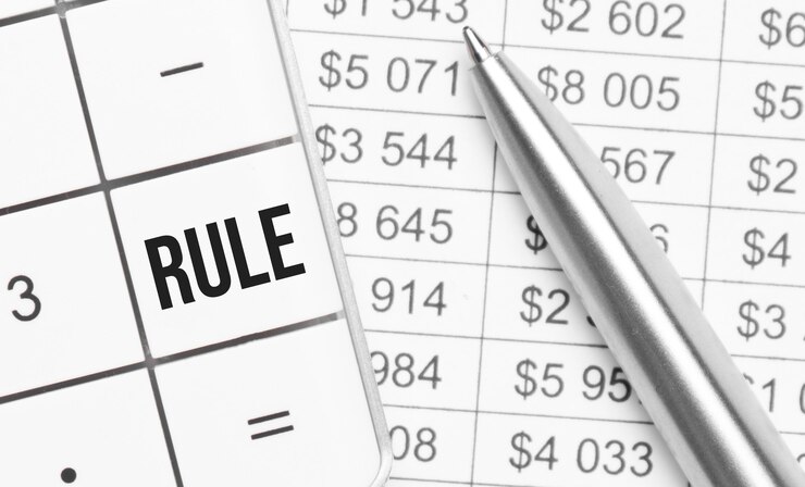 Foto negocios y finanzas. sobre la mesa hay un informe, un bolígrafo y una calculadora, en cuya tecla grande está escrito: regla
