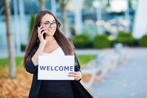 Negocios de mujeres con el cartel con mensaje de bienvenida