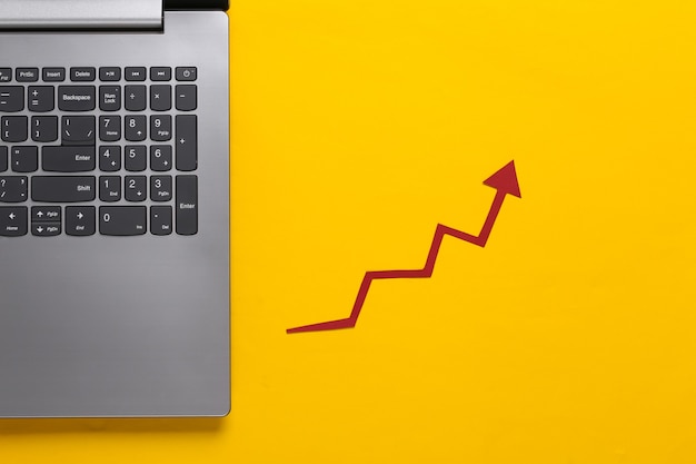 Negócios online, comércio. laptop e com uma seta de crescimento vermelha em amarelo. gráfico de setas subindo.