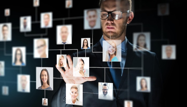 Foto negocios, personas, empleo, tecnología y concepto de red: cierre de un hombre de negocios que toca la pantalla virtual con iconos de contacto sobre un fondo oscuro