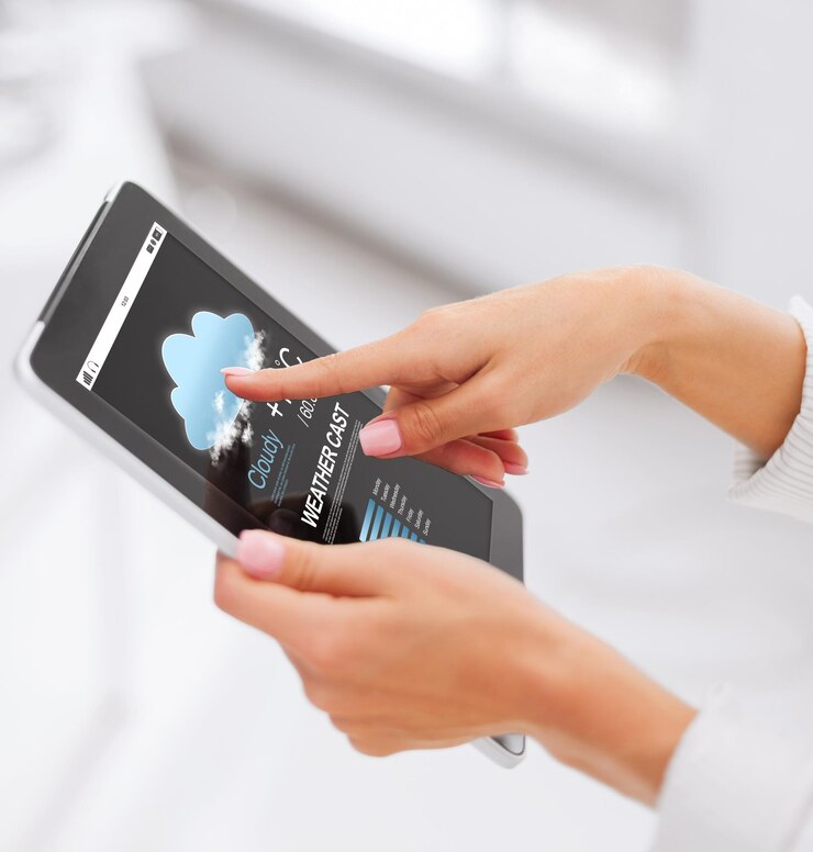 Foto negocios, personas, tecnología y concepto de pronóstico del tiempo: cierre de manos femeninas con aplicación de pronóstico meteorológico en la pantalla de la computadora de tablet pc