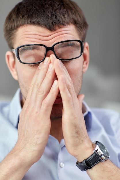 negócios, pessoas e conceito de trabalho - empresário cansado com óculos no escritório