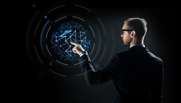 negocios, tecnología futura, ciberespacio y personas - hombre de negocios con traje y anteojos señalando con el dedo la proyección virtual sobre fondo negro