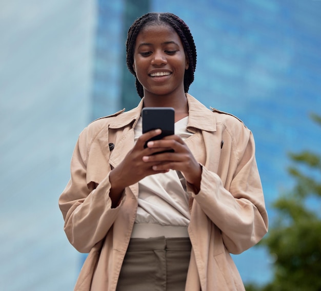 Negocios telefónicos y mujeres negras escribiendo en la ciudad navegando por Internet o en las redes sociales Tecnología celular o empleada con teléfono inteligente móvil 5g para redes de investigación o desplazamiento web en la ciudad