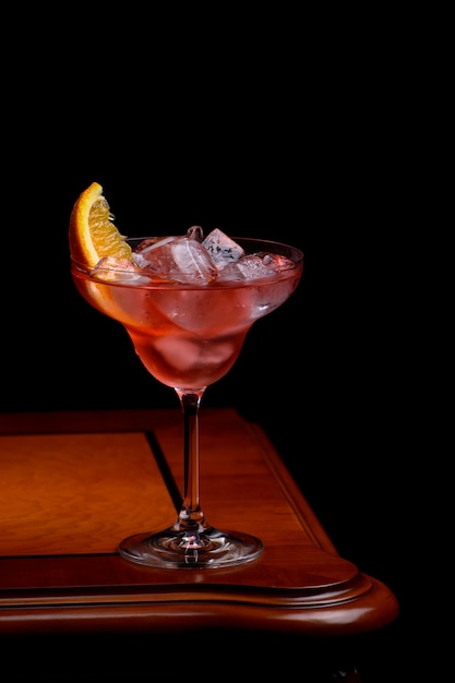 Foto negroni cocktail com fatia de laranja na mesa de madeira antiquada clássica