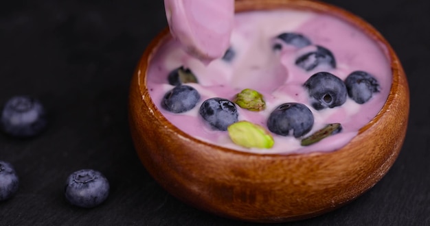 nehmen Sie einen Löffel purpurfarbenen Joghurt mit Aroma und Beeren