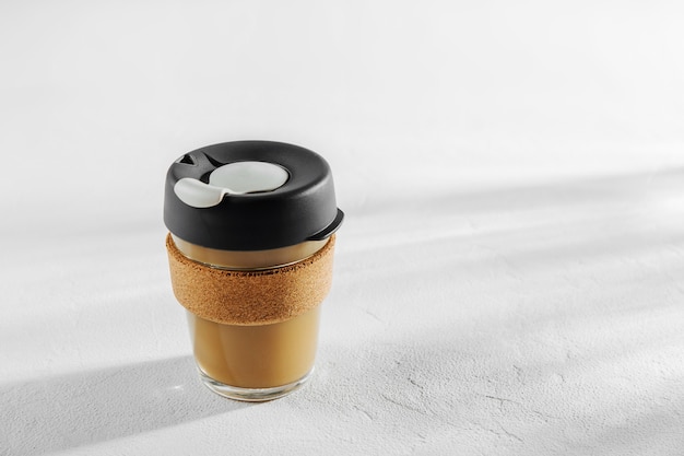 Nehmen Sie Ihren Kaffee zum Mitnehmen mit dem wiederverwendbaren Reisebecher aus Glas und Korkband. Kein Verlust. Nachhaltiges Lifestyle-Konzept.