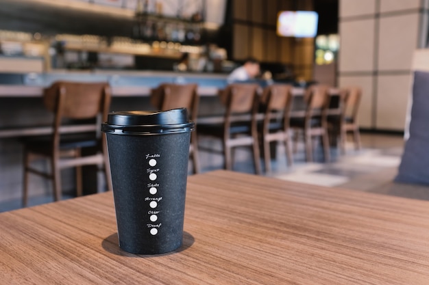 Nehmen Sie Kaffeetasse auf Holztisch im modernen Café weg