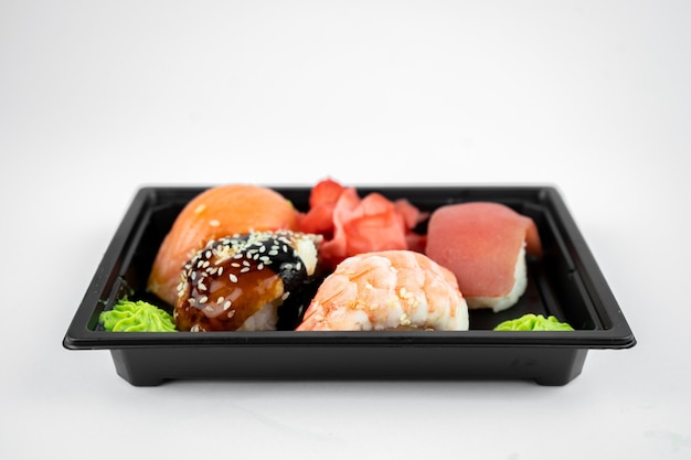 Nehmen Sie Sushi in Plastikbehälter, rosa Ingwer, Wasabi. Sushi-Lieferkonzept