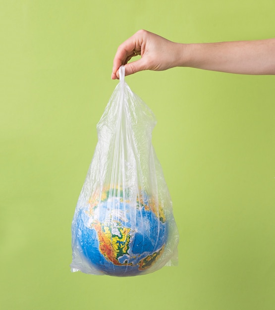 Nenhum conceito de plástico. mãos segurando o planeta Terra em saco plástico.