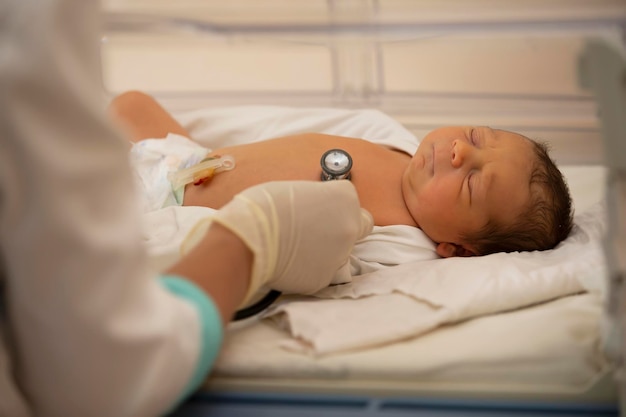 Neonatologe, der den Herzschlag eines Neugeborenen in einem Säuglingsinkubator abhört