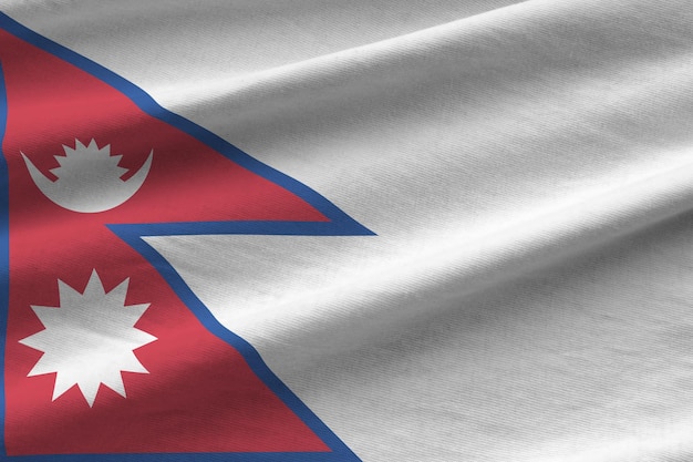 Nepal-Flagge mit großen Falten, die in der Nähe unter dem Studiolicht im Innenbereich winken Die offiziellen Symbole und Farben im Banner