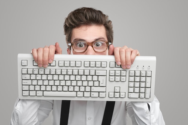 Nerd in Brille mit Tastatur im Studio