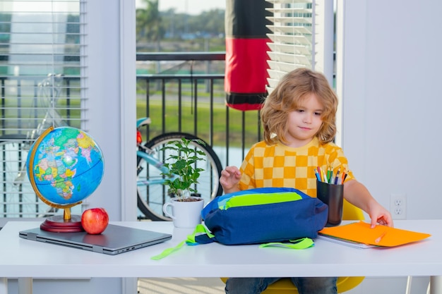 Nerd-Schulkind, das zu Hause Hausaufgaben macht Kluges Kind aus der Grundschule steckt Schulmaterial in einen Rucksack Vorbereitung auf die Schule Kluges Genie-Intelligenz-Kind bereit zu lernen Hartes Lernen