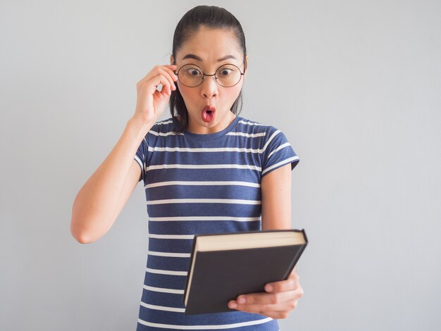 Nerdy asiatische Frau hat eine überraschte Idee von dem Buch.