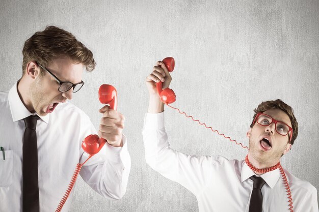 Nerdy Geschäftsmann mit Telefon vor weißem und grauem Hintergrund