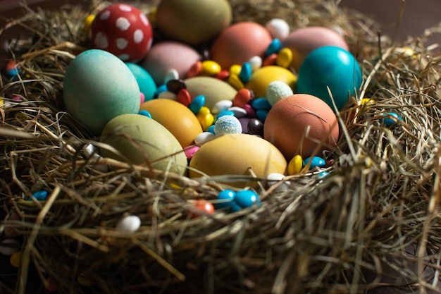 Nest aus bunt gefärbten Ostereiern und Pralinen