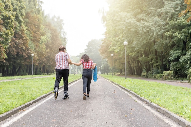 Neta e avó andando de patins e skate no parque