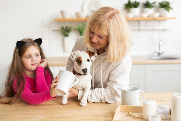 Neta e avó felizes na cozinha com a avó do cachorro jack russell terrier e