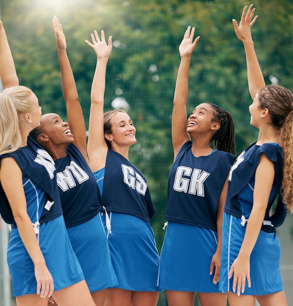 Foto netball esportes e motivação com uma equipe feminina em comemoração após a vitória em um jogo competitivo em uma quadra colaboração e treinamento de fitness com um grupo vencedor de atletas femininas na prática