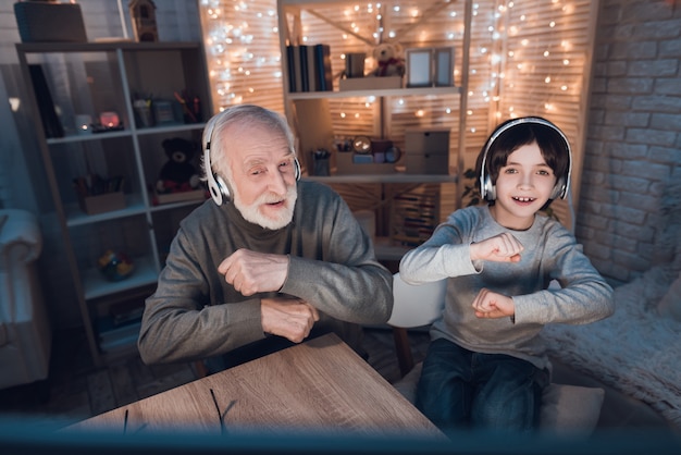 Neto e vovô ouvindo fones de ouvido de música