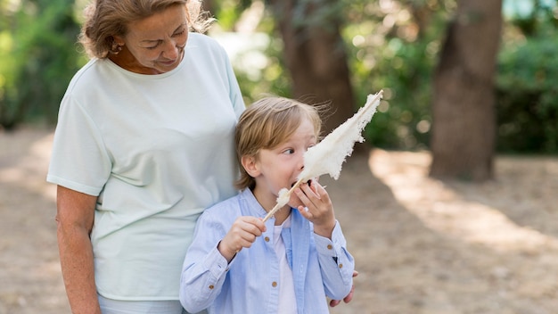 Foto neto mediano comendo algodão doce