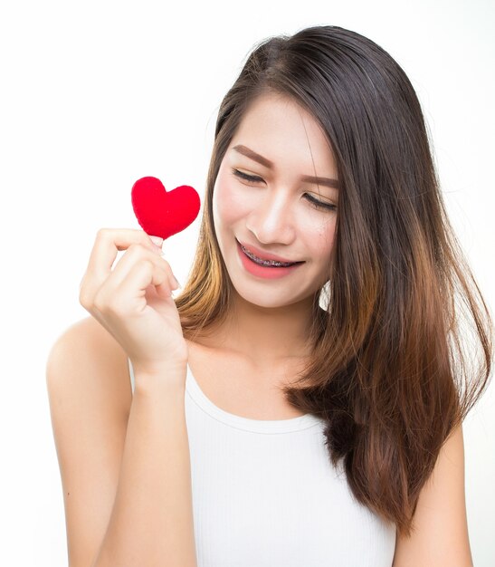 Nette attraktive junge Frau mit rotem Herzen. Valentinstag Kunst Porträt.