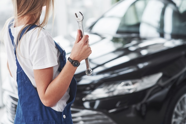 Nette blonde Reparaturfrau ist auf ihrer Arbeit. Drinnen im Autohaus