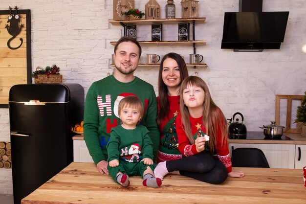 Nette Eltern und ihr nettes Tochtermädchen und Baby, die zu Hause auf Weihnachten warten